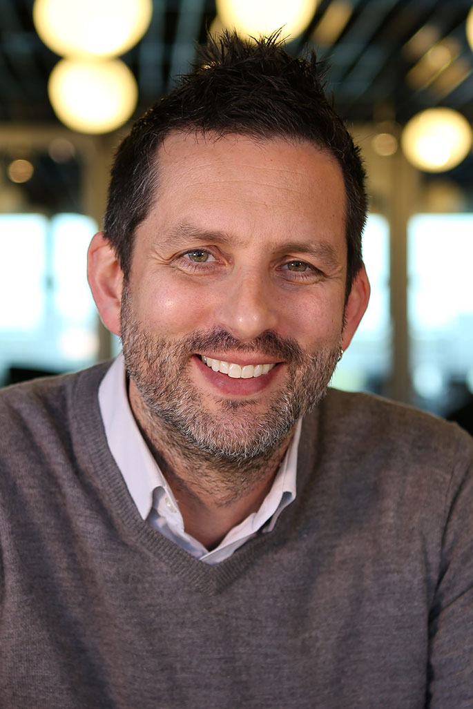 A headshot featuring Anthony Cece smiling and facing the camera.